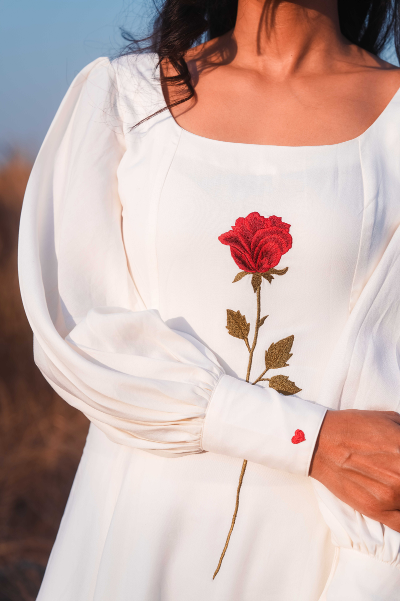 White dress with red rose embroidery and matching cuff detail.